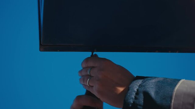 Close‑Up on Worker Hand Tightening Panel Screw Under Outdoor Cladding