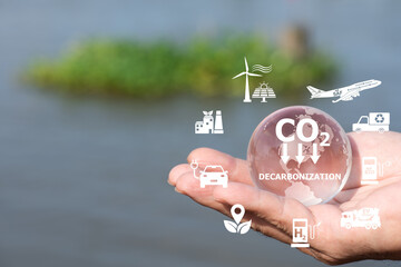 DECARBONIZATION text on glass world and icons on natural background.