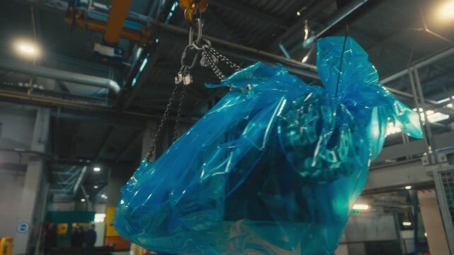 Heavy Machine Wrapped in Blue Plastic Lifted by Industrial Crane Inside Maintenance Facility