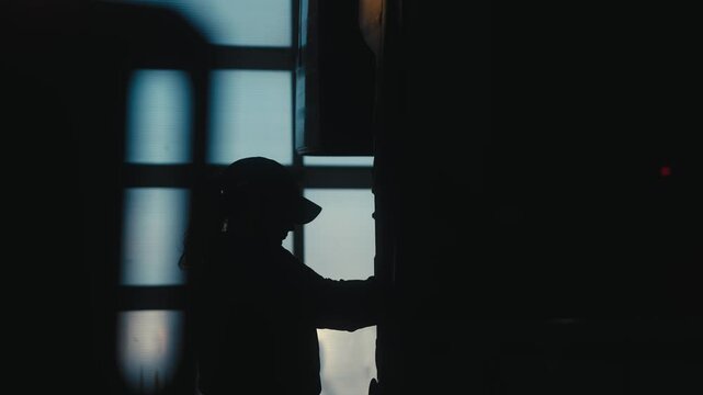 Silhouette of Woman Working by Large Machine