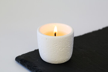 White ceramic scented candle burning