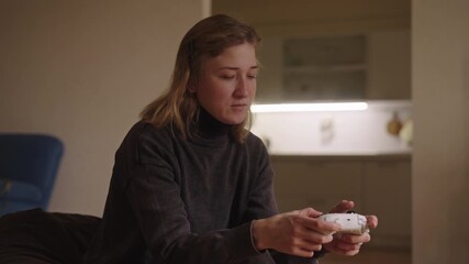 Young woman living with cerebral palsy focusing on video game controller, finding enjoyment and engaging in favorite hobby within comfort of home. Concept of diversity, equity, inclusion, DEI.