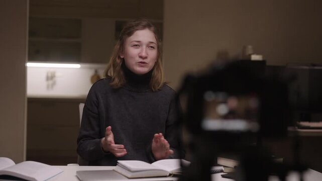 Motivational young woman with cerebral palsy and spasticity energetically gesturing and speaking while vlogging about journey, empowerment and inclusive everyday life at home. Shooting in slow motion.