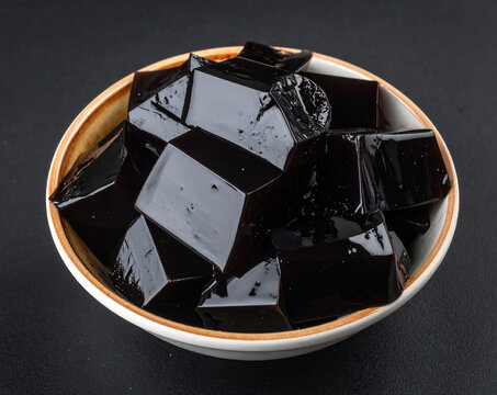 A bowl of grass jelly isolated on a black background