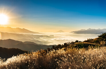 夜明けの高ボッチ高原から諏訪湖の雲海と遠くにそびえる富士山