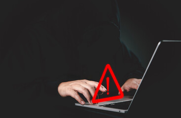 Hacker cyber security threat warning sign data breach privacy risk technology attack internet scam malware dark background computer laptop keyboard.