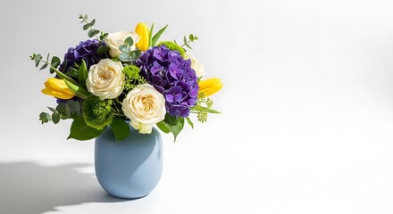 Naklejka premium Beautiful floral arrangement in a blue vase isolated on white background