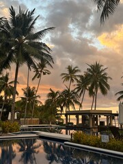 Obraz premium Sunset Reflections at Tropical Resort Pool with Palm Trees, Philippines