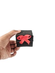 Hand holding a gift box wrapped with a red ribbon on a white background. Black Friday