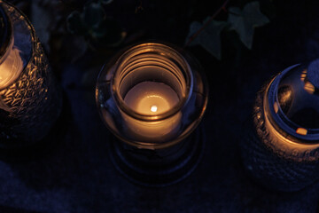 Nastrojowe ujęcie cmentarza po zmroku, gdzie jedynym źródłem światła są palące się znicze. Migoczące płomienie tworzą ciepłą, melancholijną atmosferę, podkreślając duchowy i refleksyjny wymiar miejsca © Michał.S-FOTO