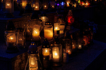 Nastrojowe ujęcie cmentarza po zmroku, gdzie jedynym źródłem światła są palące się znicze. Migoczące płomienie tworzą ciepłą, melancholijną atmosferę, podkreślając duchowy i refleksyjny wymiar miejsca © Michał.S-FOTO