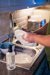 A man washing dishes in the kitchen, home chores, daily routine