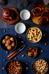 Food themed still life with crockery, various nuts and tea. Flat lay. Top view.