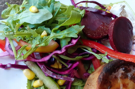 Nottingham, England, August 3, 2022. A mixed salad full of colors, full of contrasting flavors and excellent for health. There are arugula, beetroot slices, red pepper strips, chopped red cabbage,corn