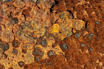 Close-up of weathered rust texture with peeling layers and warm orange patina, detailed industrial surface background
