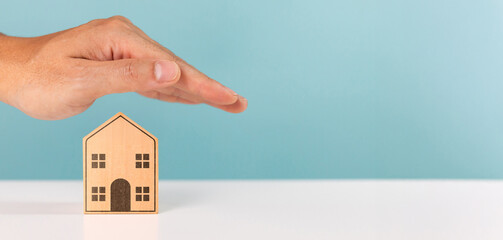 Protect property, mortgage, home, investment and financial savings concept. A man protecting roof...