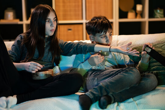 Siblings fighting over remote control during movie night