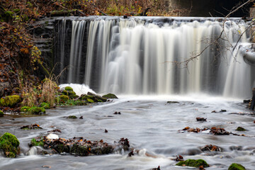 A long exposure view of a waterfall in a small rapid river, autumn landscape, November in nature, Ieriku mill, Melderupe, Latvia