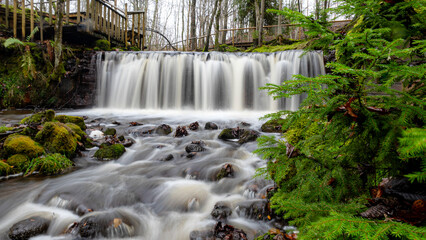 A long exposure view of a waterfall in a small rapid river, autumn landscape, November in nature,...