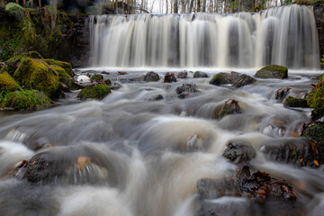 A long exposure view of a waterfall in a small rapid river, autumn landscape, November in nature,...