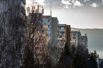 Row of insulated old tower apartment buildings at sunset in Romania.