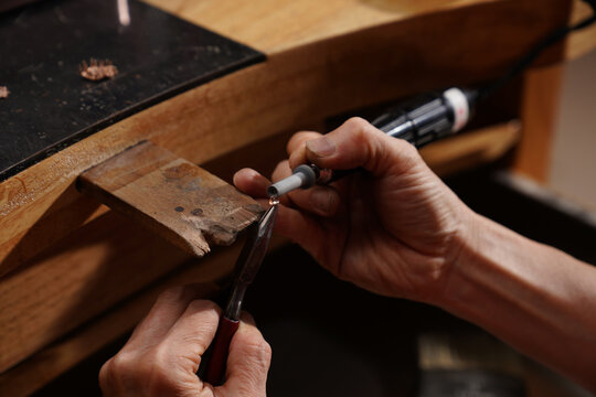 Jeweler at Work: Capturing the intricate craftsmanship of a jeweler as he meticulously works on a precious gem, shaping it with precision and skill.