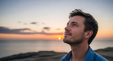 Man gazing at sunset over ocean, contemplating lifes beauty and wonder.