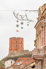 A cozy, festive street in Vilnius Old Town with Gediminas tower and Christmas decorations and ornaments creating a charming holiday atmosphere