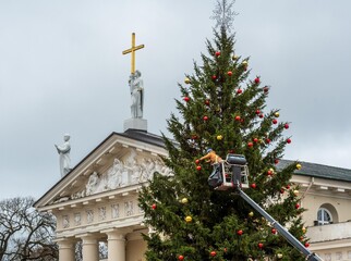 Workers decoration the Christmas tree with baubles in Cathedral square in Vilnius, Lithuania 