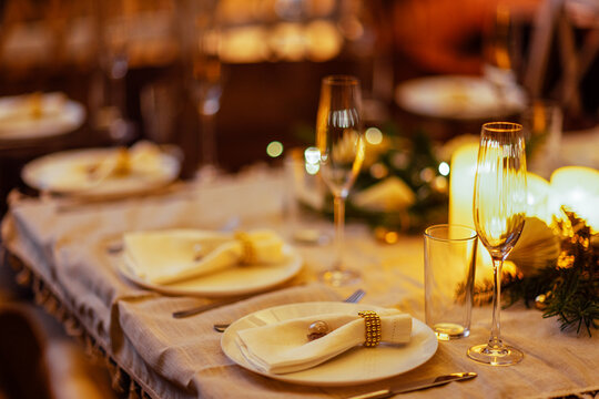 Elegant dining table set for a festive celebration, adorned with fine china, sparkling glassware, and decorative greenery, creating a warm and inviting atmosphere for guests