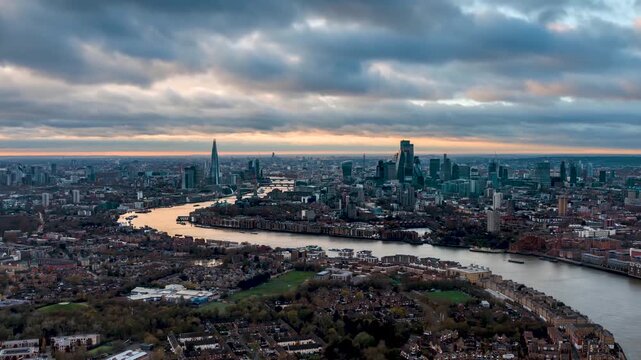 Fast moving time lapse view of the London skyline during a autumn sunset with river Thames and city skyscrapers under changing cloudscape
