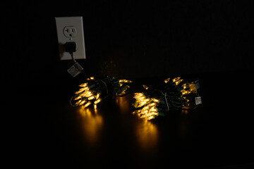 yellow christmas lights plugged into the wall