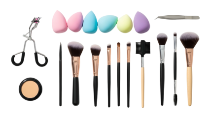Assortment of makeup tools laid out, including sponges, brushes, eyelash curler & compact
