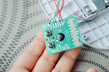 Disassembled electronic device kitchen scales with circuit board wires plastic parts on a table.Useful for articles about electronics repair, DIY projects, device maintenance and engineering tutorials