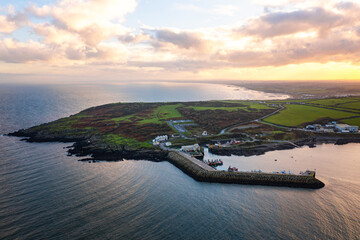 Aerial view of Port Oriel in Clogherhead with fishing boats and hazy evening light along the calm coastline
