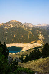 Low water level of Lac de l&rsquo;Oule at sunrise, seen from a hiking trail between Col de Portet and Refuge du Bastan