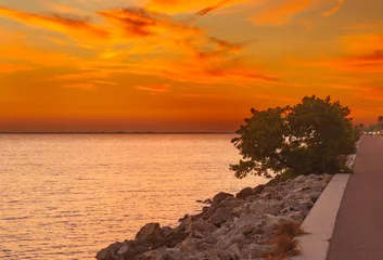 Selbstklebende Fototapeten Tiefes Orange This stunning image captures the Howard Frankland Bridge at sunset, showcasing vibrant sky colors reflected across the calm coastal waters.   © Bo