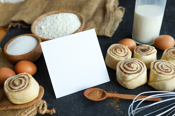 Freshly baked cinnamon rolls with ingredients and blank card for text