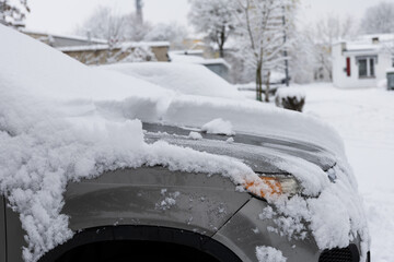 częściowo odśnieżony samochód zimą. 