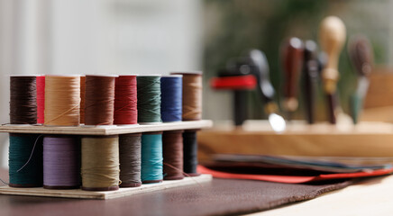 Concept choosing threads color for handcrafted leather shoes and bags production, tailor workplace