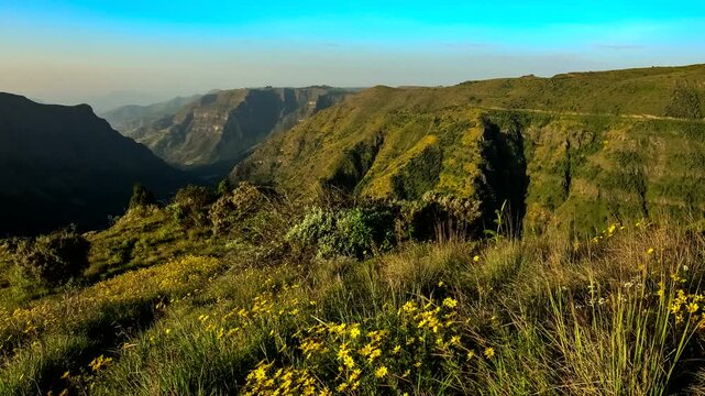 Ethiopia. Simien Mountains National Park. Breathtaking view from Sankaber Camp view point of mountain slopes and flower-filled meadows bathed in the rays of the rising sun. Timelapse Ultra HD Video