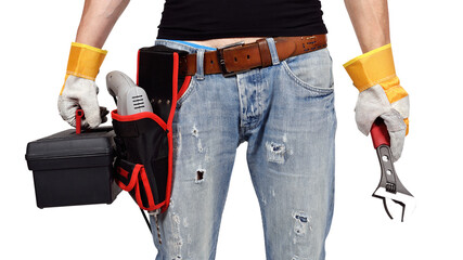 A mechanical engineer stands in gloves, drill, wrench and toolbox