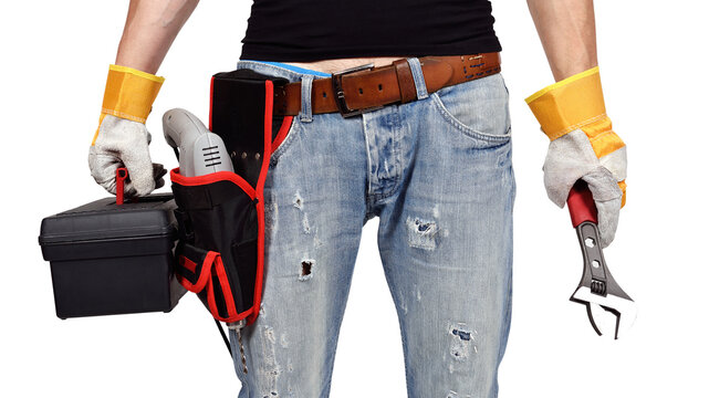 A mechanical engineer stands in gloves, drill, wrench and toolbox