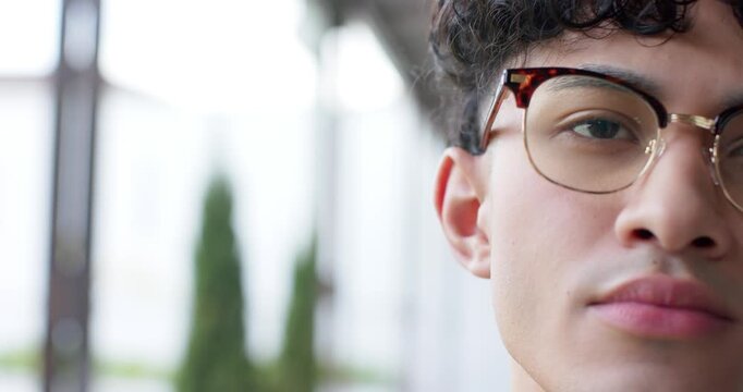 Man holding forward gaze by window with glasses blinking slowly and maintaining vision, copy space