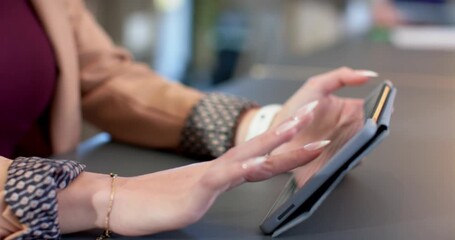 Right hand entering frame, swiping tablet on smooth office desk while navigating digital content - Powered by Adobe