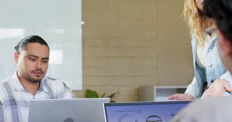 Male coworker studying chart to analyze data as presenter highlighting figures on board in office - Powered by Adobe