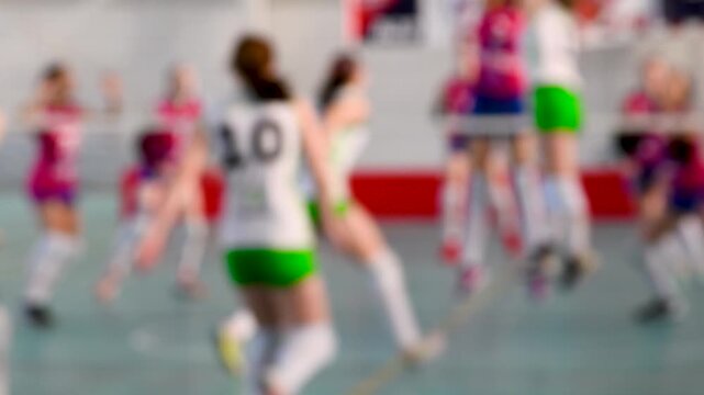 Group of teen girls playing indoor volleyball. Sport background blur.