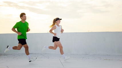 Couple jogging on a rooftop during late afternoon