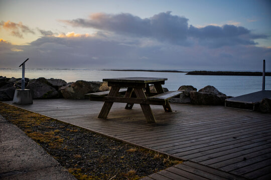 Wooden Picnic Table on Coastal Boardwalk at Sunset, Iceland