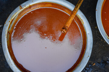 Thick, Sweet Syrup: Close-Up of Date Jaggery (Patali Gur) with a Wooden Stirrer